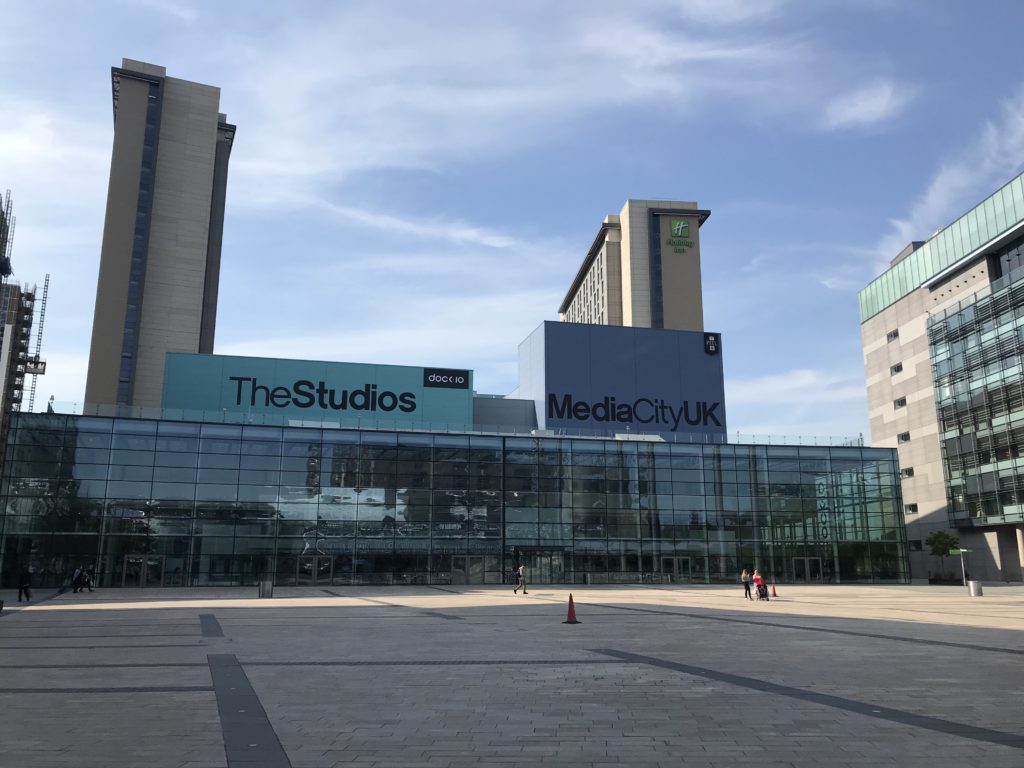 The Media City UK Sign sits on top of a BBC Studios building in Manchester. 